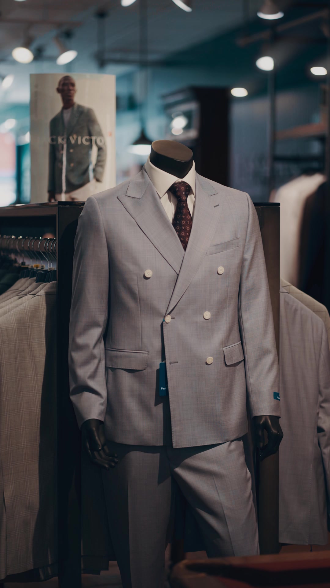 Light grey double-breasted suit displayed on a mannequin in store